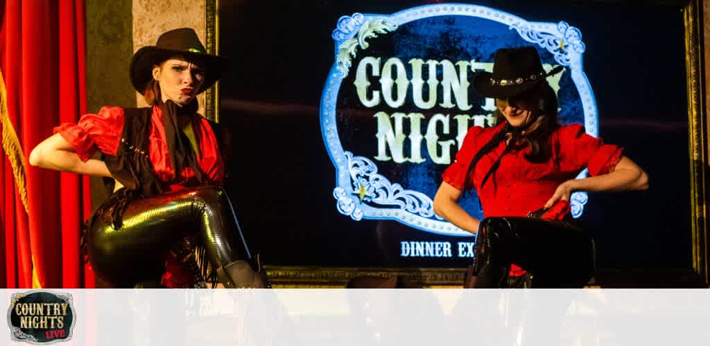 Two performers in cowboy hats and red shirts pose onstage at a "Country Nights Live" dinner event.