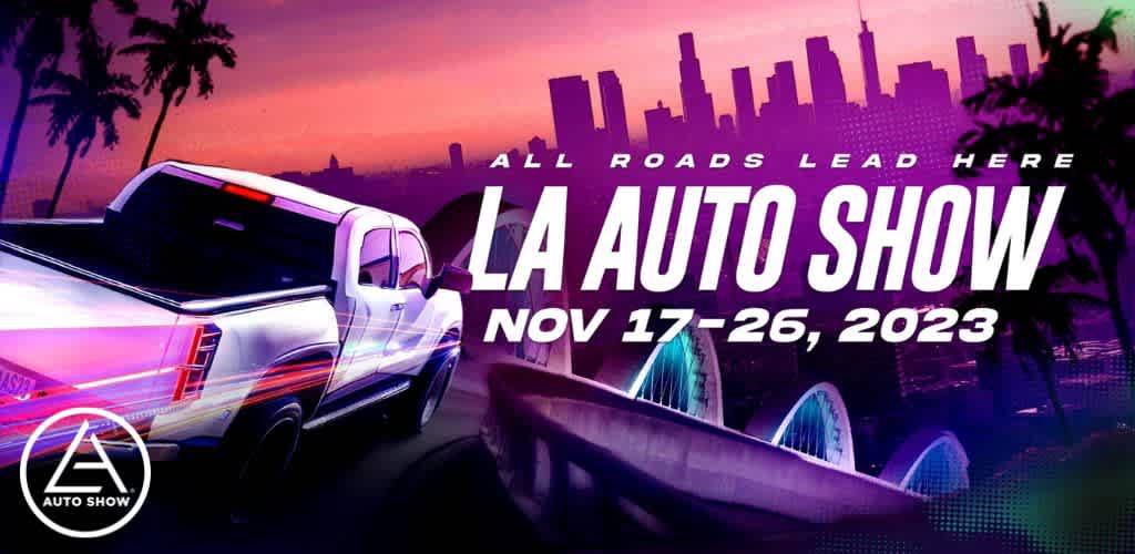 This image features a vibrant promotional banner for the 'LA Auto Show' with the dates "NOV 17-26, 2023" prominently displayed. A sleek, modern white truck is shown on the left side of the banner, with stylized reflections and light streaks giving an impression of speed and movement. The background depicts a sunset or sunrise with a purple and pink sky above a silhouette of a city skyline, likely representing Los Angeles. The skyline silhouette includes recognizable high-rise buildings and palm trees. In the foreground, the iconic outline of a bridge, possibly hinting at Los Angeles' infrastructure, is seen. The text "ALL ROADS LEAD HERE" is written across the top in bold, stylized lettering, adding to the event's allure. The logo for the LA Auto Show, a stylized 'A' with a star creating a dynamic triangle, is positioned in the lower left corner, reaffirming the event's brand identity.

For those planning to attend the LA Auto Show, FunEx.com offers great discounts, ensuring savings on tickets without compromising on the excitement of experiencing the latest in automotive innovation.