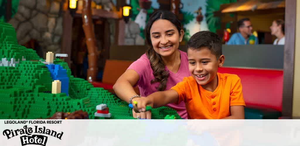 A woman and a boy smiling at a Lego model inside LEGOLAND's Pirate Island Hotel.