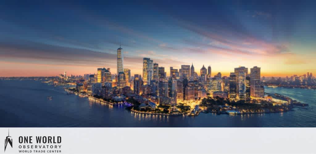 A panoramic view of a city skyline at dusk with skyscrapers and waterfront. The sky gradients from warm orange to blue above. One World Observatory logo appears at the bottom.