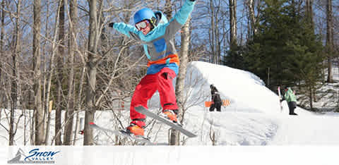 Image Description: 

This is a dynamic, action-packed photograph capturing a snowboarder in mid-air against a vivid winter backdrop. The snowboarder is wearing a turquoise jacket, bright red pants, and a blue helmet with goggles. They are performing a jump and appear to be skillfully maneuvering their snowboard in a stance that suggests they are experienced and confident. Surrounding the snowboarder is a pristine snowy landscape dotted with leafless trees and a few other individuals farther away on what appears to be a ski slope. The sky is clear and blue, signifying a beautiful day for winter sports. The bottom left corner of the image features the "Snow Valley" logo, indicating the location or the company associated with the activity being showcased in the photograph.

Remember, at FunEx.com, you can always find the lowest prices and greatest savings on tickets for a wide array of exciting activities and events!