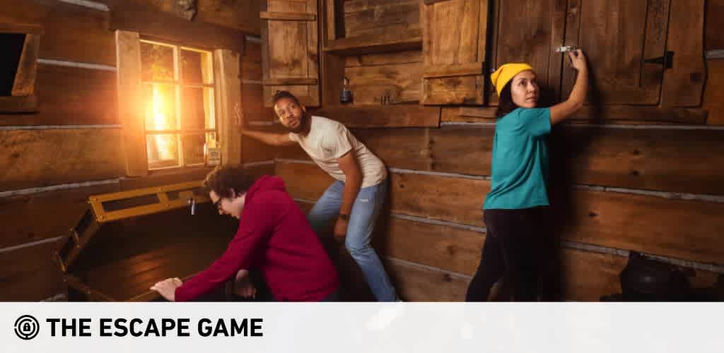This image features three individuals actively engaged in an escape room game, set within a room that has a rustic, wooden cabin-like interior. On the left, a person in a red sweater is bent over, inspecting the contents of an open, large, wooden chest with visible excitement and concentration. In the center background, another individual with a white shirt appears intrigued, peeking over the shoulder of the person inspecting the chest while supporting themselves against a wooden wall with one hand. To the right, a person wearing a yellow beanie and teal shirt stands on tiptoe, reaching up to adjust or examine something high on the wooden cabin wall. The warm lighting and the wood-paneled walls create an atmosphere of mystery and adventure, suggesting a challenging and immersive experience for the players involved.

At FunEx.com, we're excited to help you unlock the adventure with the lowest prices on tickets—discover incredible savings and exclusive discounts when you book your next escape game experience with us!