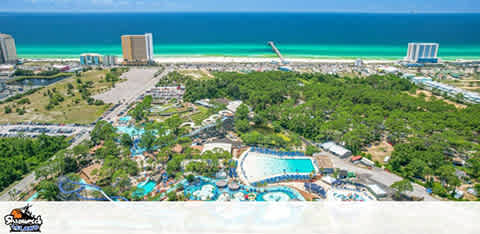 Aerial view of a waterpark with slides near a coastline with buildings.