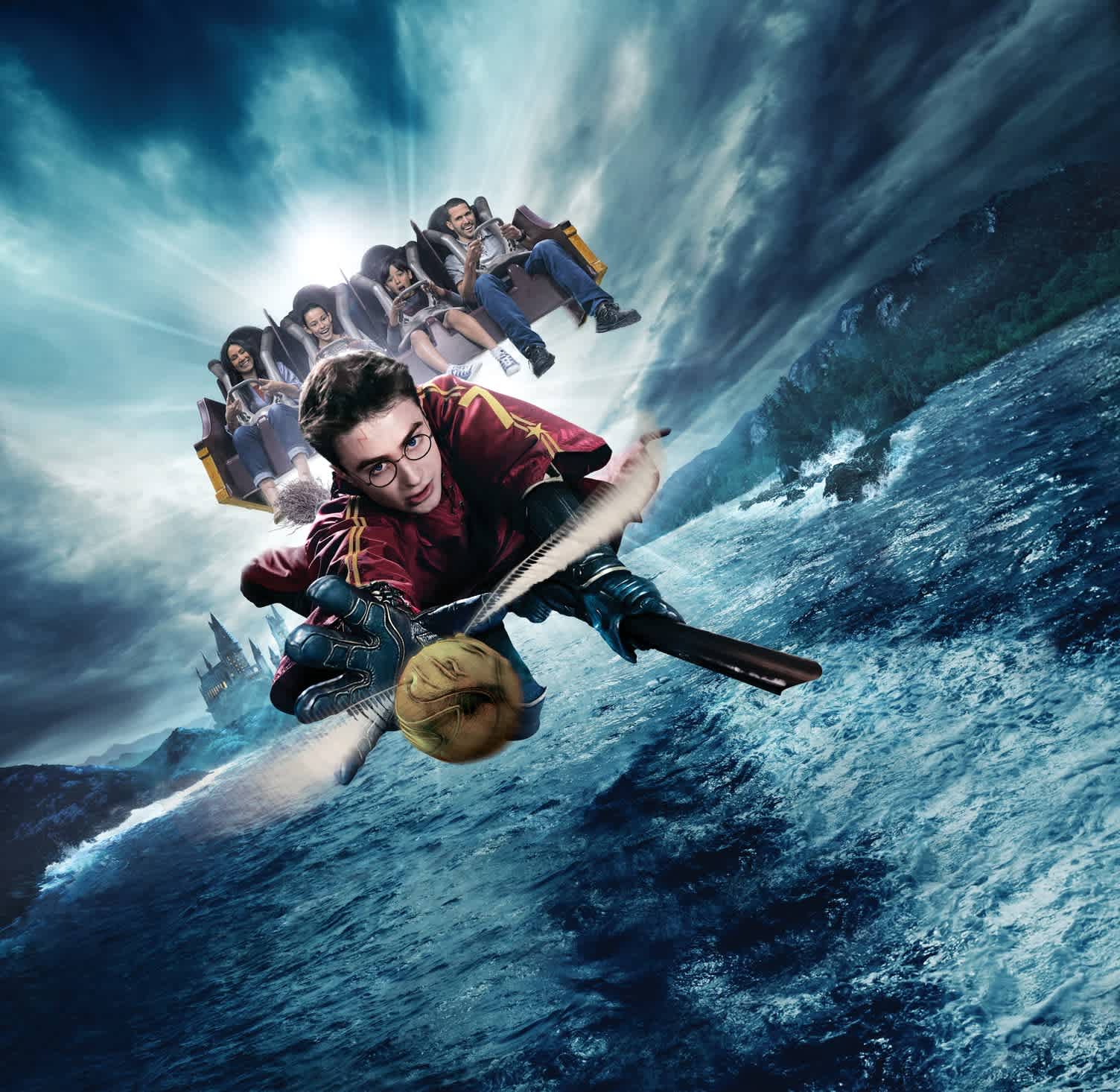 An exhilarating scene showcasing a young wizard riding a broomstick over a turbulent ocean. He's clad in a maroon and gold outfit, intently chasing a golden ball. Behind him, other ride-goers are enjoying an amusement park attraction, all against a dramatic backdrop featuring a stormy sky and a distant castle.