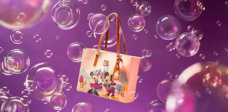 A charming tote bag featuring classic animated characters in a colorful design is set against a whimsical purple background filled with floating bubbles. The bag has brown leather straps and a playful, cheerful look, making it a delightful accessory for fans of timeless animation. Perfect for adding fun to casual outings.