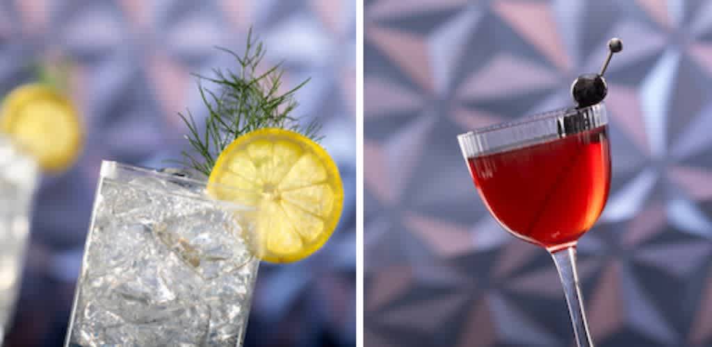 The image showcases two cocktails against a geometric background. On the left is a clear drink in a tall glass, garnished with a lemon slice and a sprig of herbs. On the right is a red cocktail in a stemmed glass, adorned with a dark cherry. The scene offers a modern and refreshing aesthetic.
