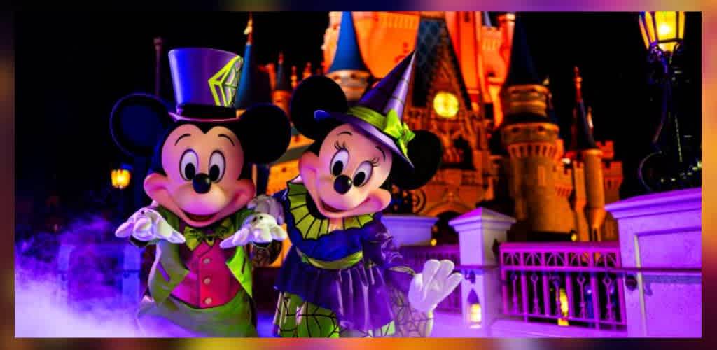 A whimsical nighttime scene features two iconic mouse characters dressed in festive Halloween costumes. They stand in front of a brightly lit castle, with one wearing a top hat and green vest, and the other in a witches hat and dress. The vibrant colors and magical lighting create a playful and enchanting atmosphere.