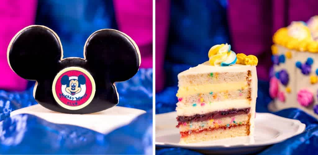 The image features two desserts set against a vibrant blue and purple background. On the left is a chocolate dessert shaped like iconic mouse ears with a playful design on the front. On the right is a slice of layered cake with colorful sprinkles and a swirl of yellow and blue frosting on top. In the background, a similarly decorated cake with vibrant decorations is partially visible.