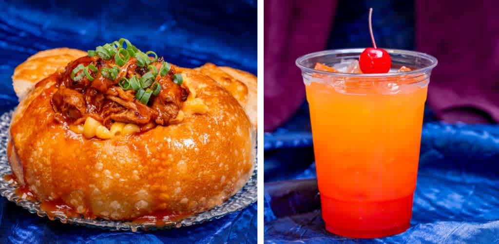 A hearty bread bowl filled with creamy macaroni and cheese, topped with pulled pork and garnished with green onions, sits on the left. On the right, a refreshing drink with a gradient from red to orange is served in a clear cup, topped with a cherry, all against a rich blue background.