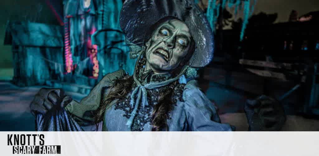 A spooky character dressed in tattered clothes and a wide-brimmed hat appears in an eerie setting. The green-tinted lighting highlights the figure's haunting features and outstretched hands. The background features a dimly lit structure adorned with ominous decorations, enhancing the chilling atmosphere. The scene captures the essence of a haunting experience.