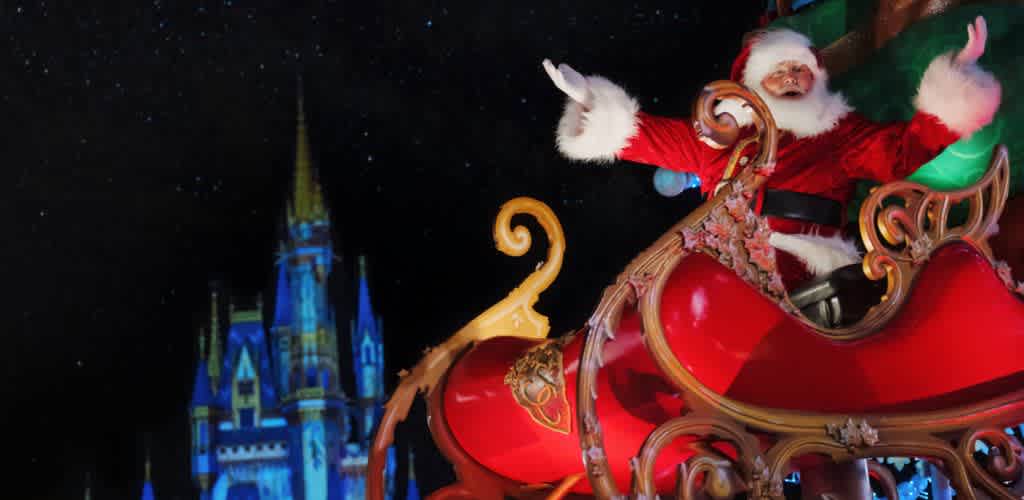 Santa Claus riding a sleigh at night in front of a castle with blue lighting