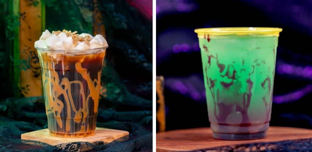 A plastic cup of iced coffee with whipped cream topped with caramel drizzle on a wooden coaster, dark background with colorful abstract patterns.