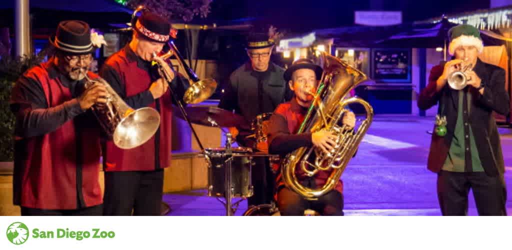 A group of five musicians play brass instruments under festive lighting at night.