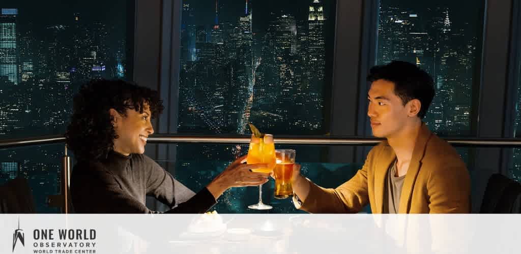 Two people toasting drinks with a city skyline as the backdrop at night.
