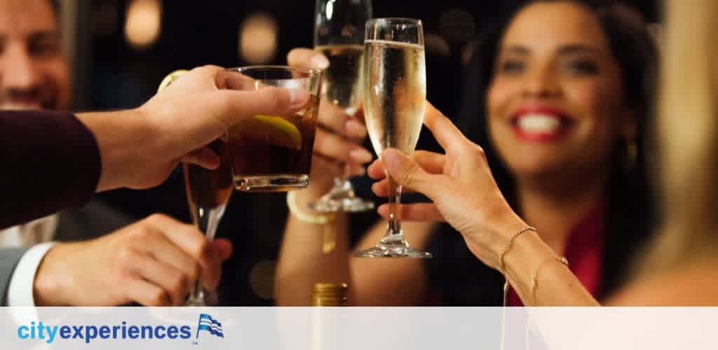 A group of people raising glasses of wine and drinks for a toast at a lively celebration or event.