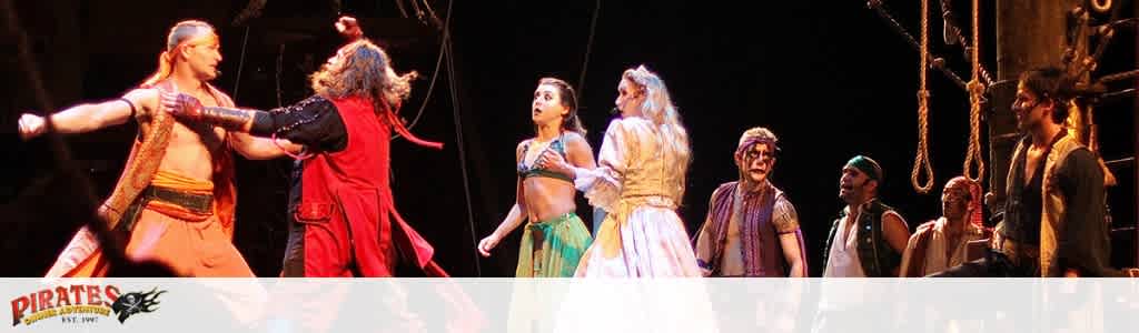 Actors perform a pirate-themed scene on stage, dressed in period costumes.