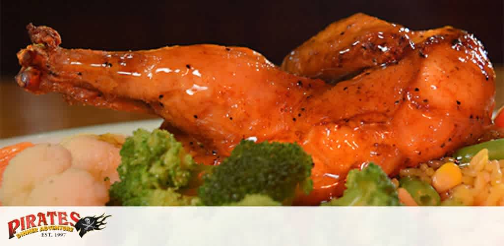 Glazed roasted chicken leg with broccoli, carrots, cauliflower, and rice on a plate.