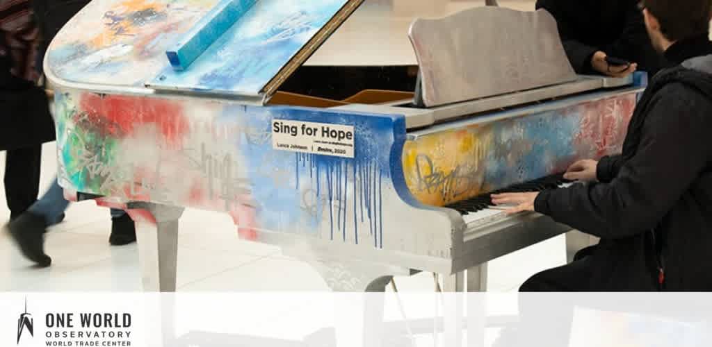 A colorful graffiti-covered piano in a public space, with two people interacting.