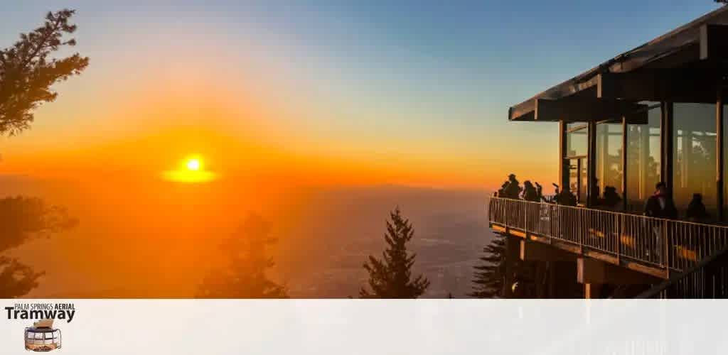 Sunset view from a glassed observation deck with silhouetted trees and people watching.