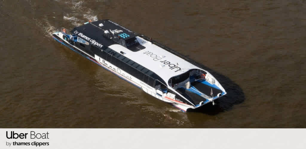 A black and white rescue boat with blue accents floating on brown water, labeled Uber Boat and Thames Clippers.