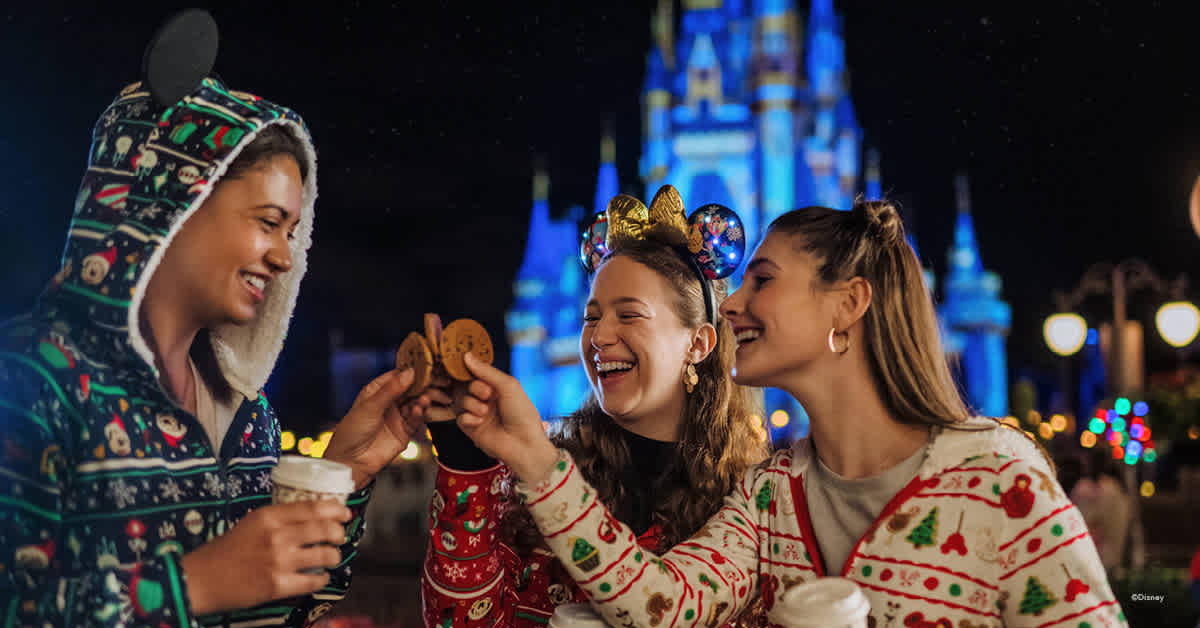 Guests enjoying holiday cookies and treats in front of Cinderella Castle