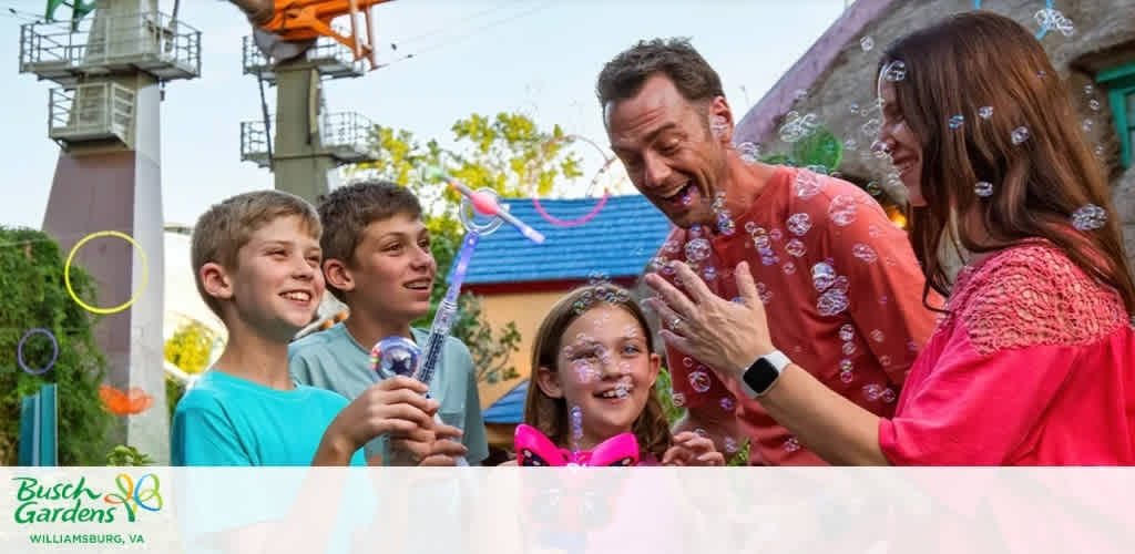 A group of happy children and adults playing with bubbles outdoors at Busch Gardens Williamsburg Virginia.