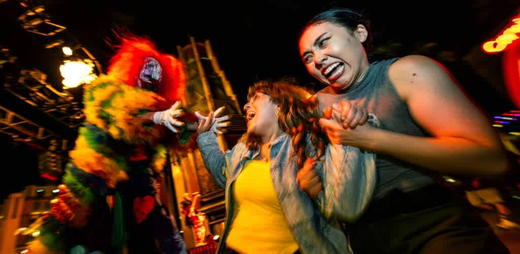 People laughing and dancing with a clown in colorful costume at a lively event