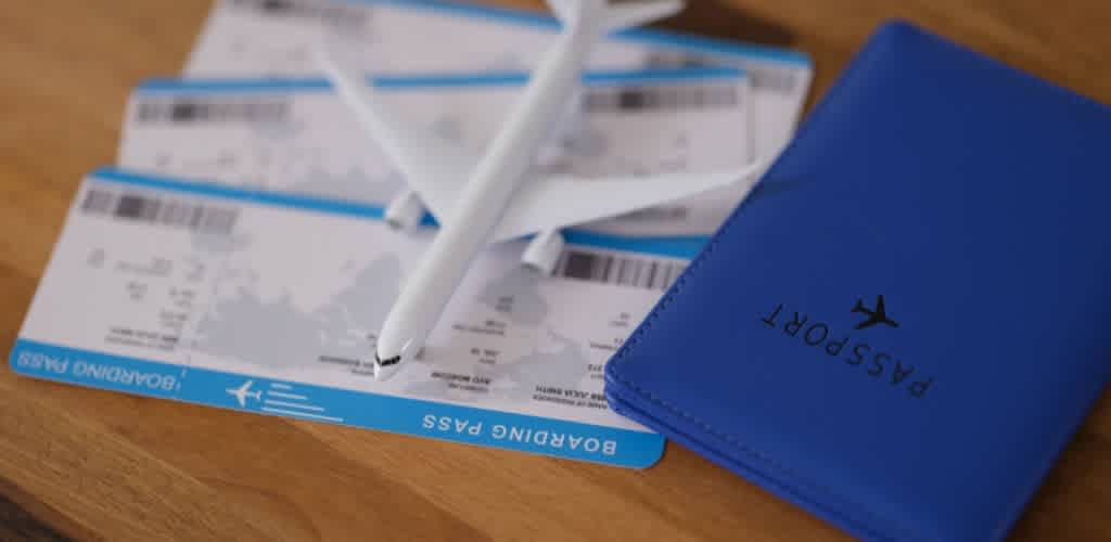 Multiple boarding passes and a blue passport holder on a wooden surface.
