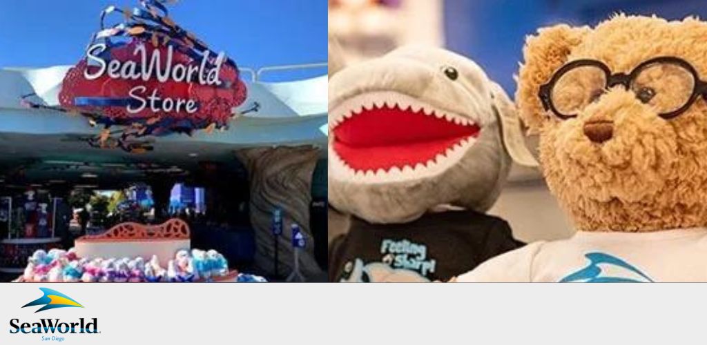 Image of a SeaWorld Store entrance with a colorful sign shaped like a fish. To the right, a person is posing with a shark puppet on one hand and a teddy bear wearing glasses on the other. The teddy bear sports a t-shirt with the SeaWorld logo. Both items appear to be merchandise from the store. The SeaWorld and San Diego logos are visible.