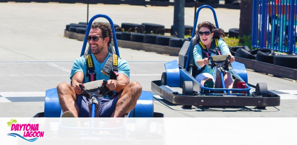 Two people enjoy go-karting on a sunny track at Daytona Lagoon.