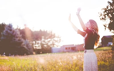 Woman raising hands to sun, © Ben White