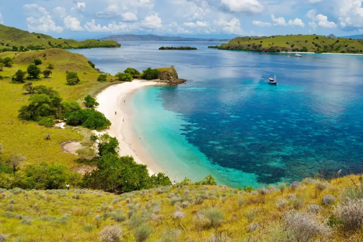 Rugged Mawi Beach coastline with surf waves and surrounding hills
