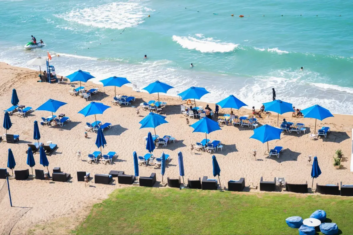 Beach with blue water and rows of sun loungers