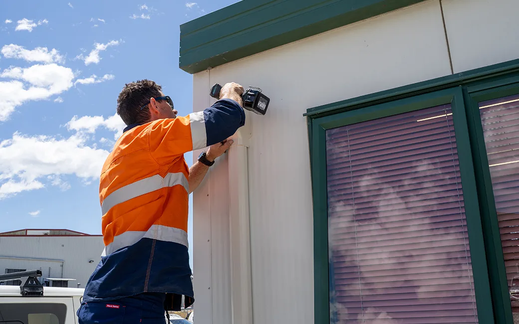 electrician repairing the side of ta building