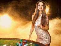 gorgeous young woman evening dress with two cards hands standing near poker table with glass of champagne