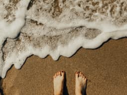 Escape The Comfort Zone Woman Feet in Sand by the Sea