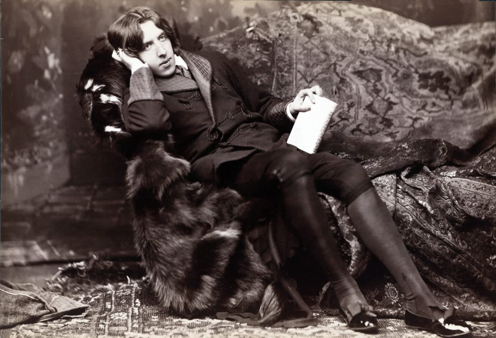 Oscar Wilde Posing on Chair Holding Book