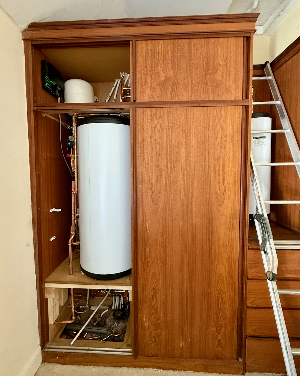 A hot water cylinder fitted inside a wardrobe