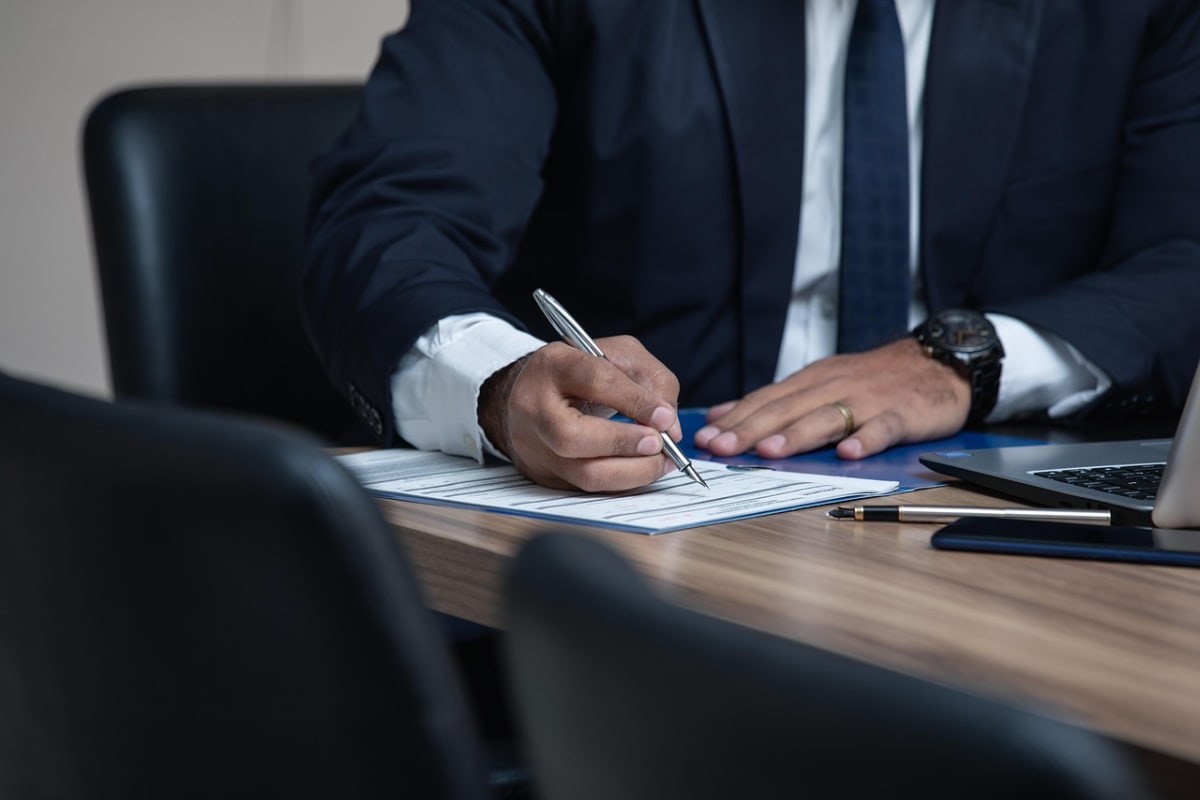Man signing contract laptop