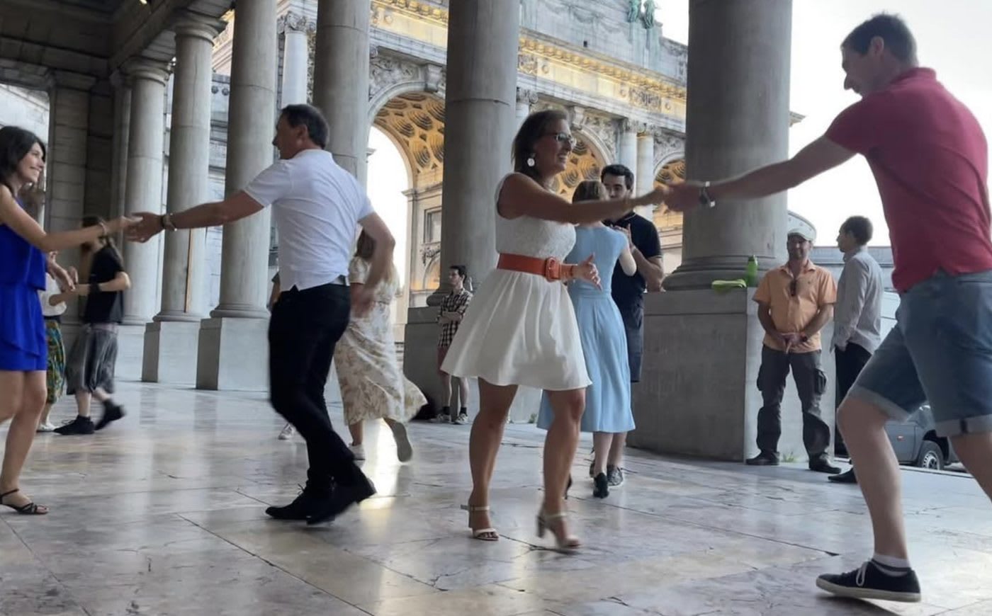 Couple dansant le rock en plein air sous des arcades à Bruxelles