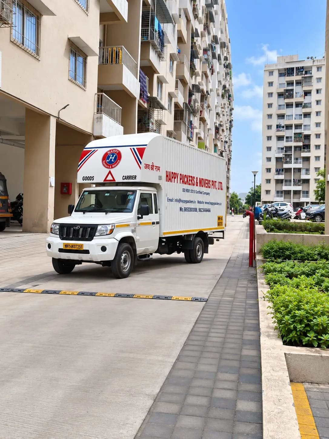 A Happy Packers and Movers truck parked at a residential apartment complex for a house move