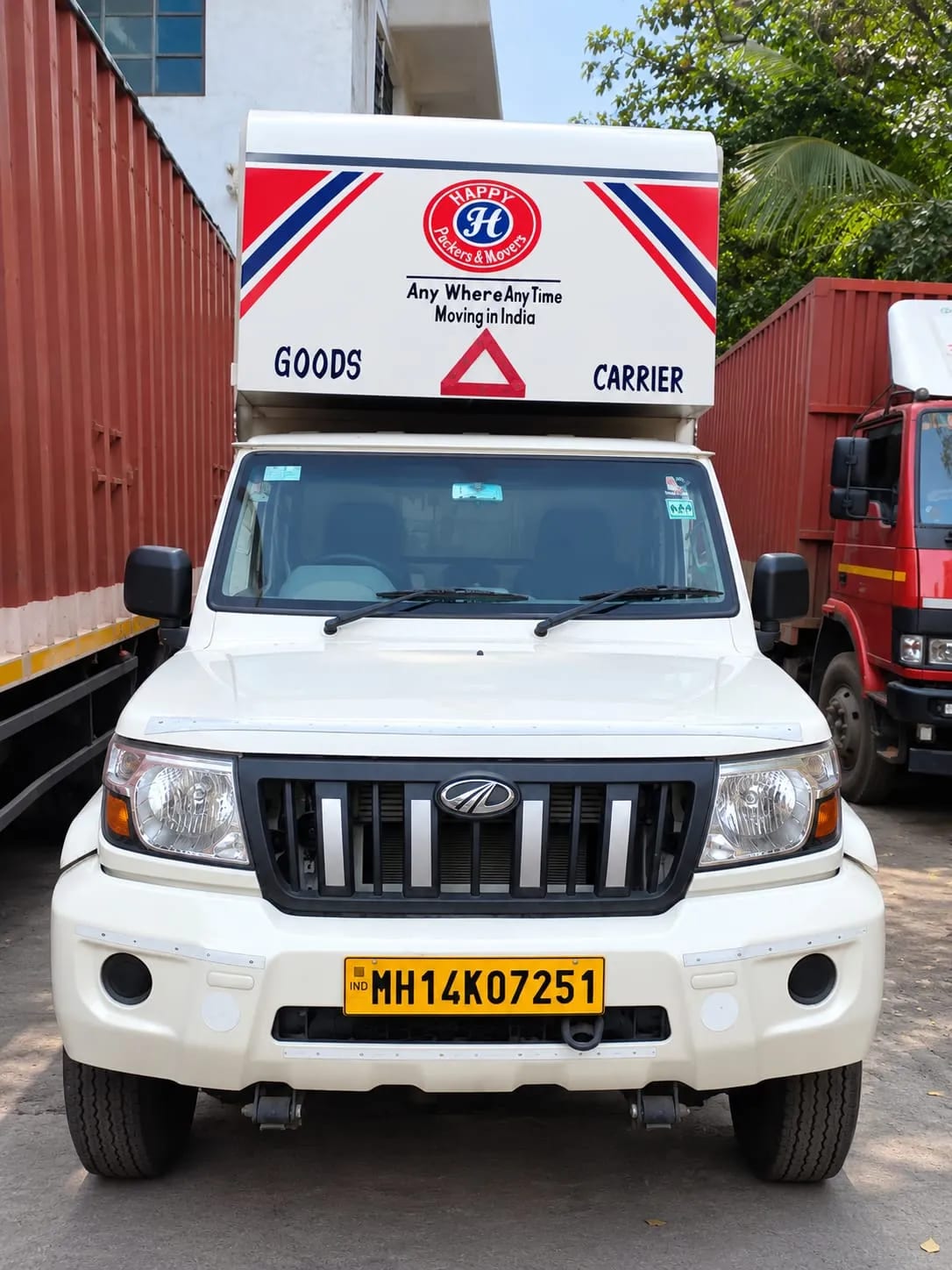 Front view of a Happy Packers and Movers goods carrier truck