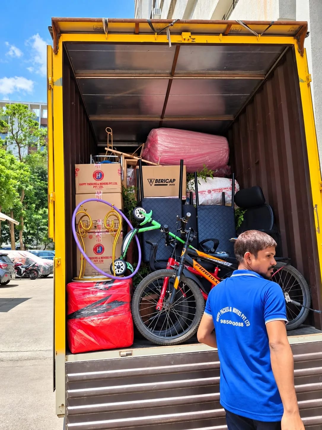 Household goods, sealed cartons and a child's bicycle loaded into a moving container