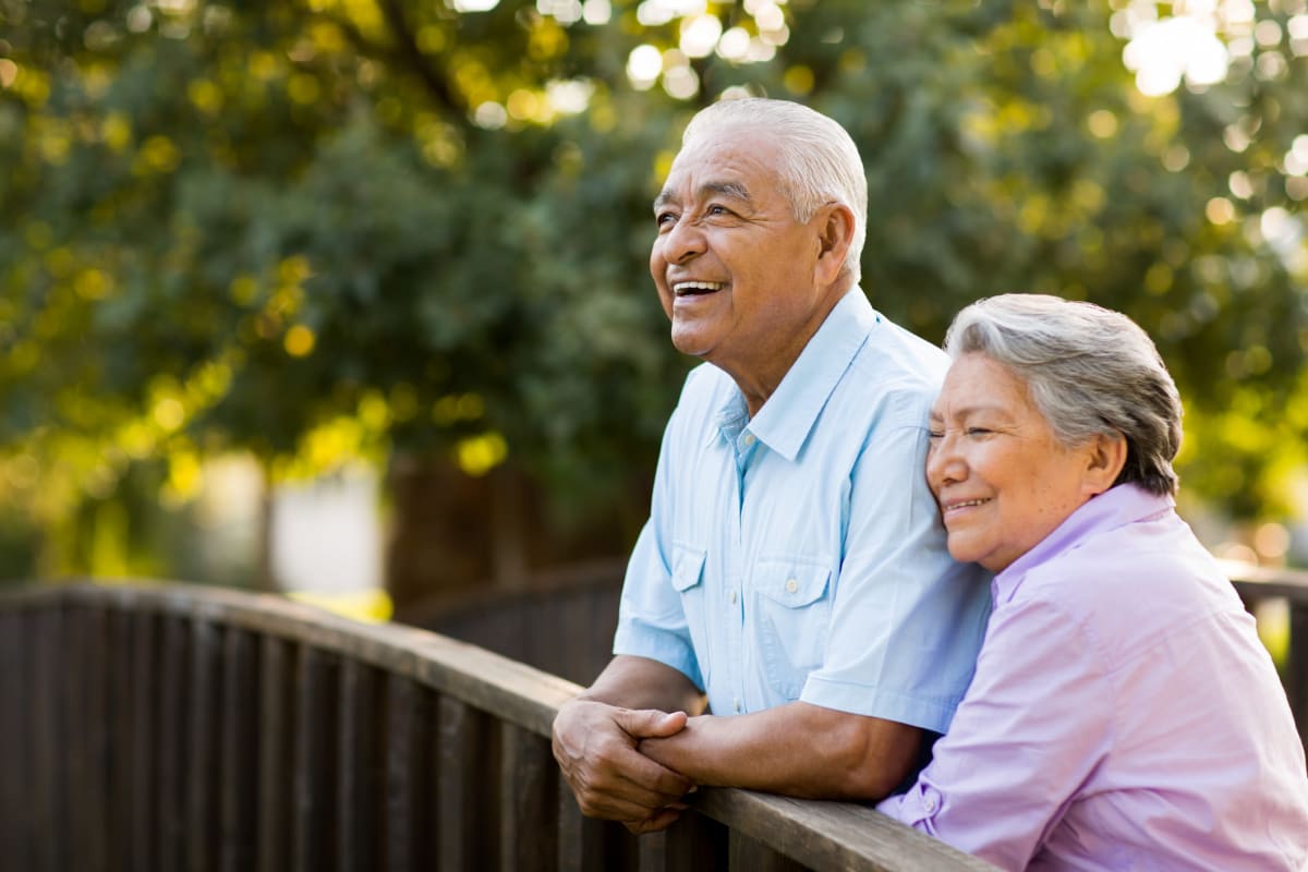 Resident couple walking over a bridge in a park near Citrus Place in Riverside, California