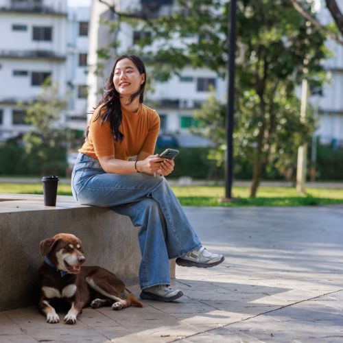Woman sitting with her dog and enjoying time outdoors near North Road Townhomes in Scottsville, New York