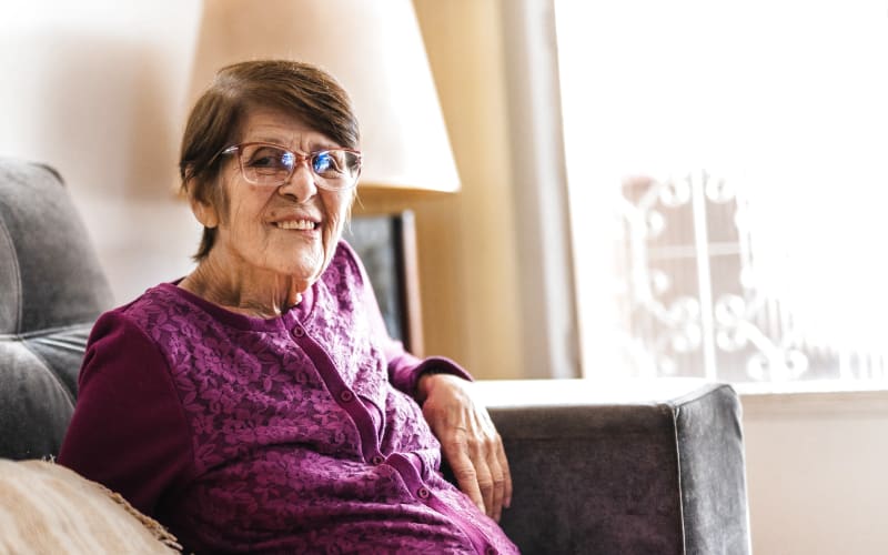 Resident relaxing in the living room of her apartment at Grand Villa of Boynton Beach in Boynton Beach, Florida