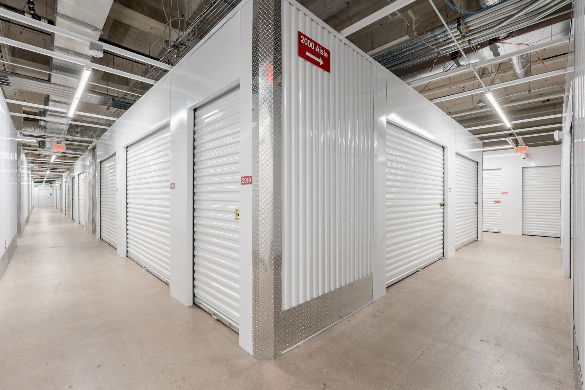 Storage facility hallway with white roll-up doors at Park Central Self Storage in Phoenix, Arizona