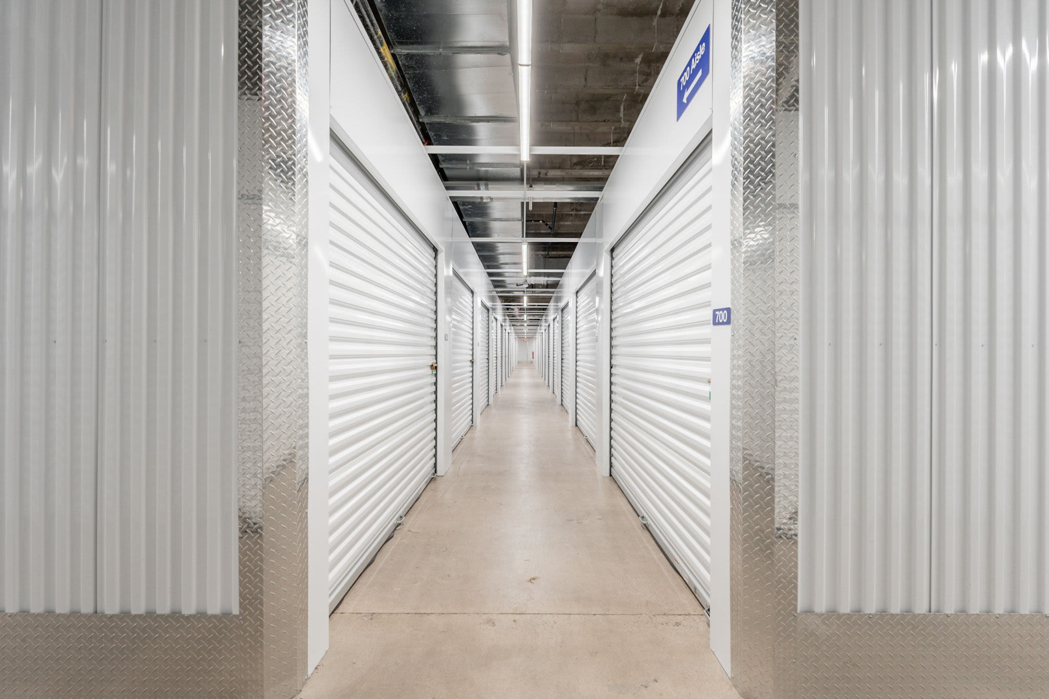 Hallway with white storage unit doors on both sides at Park Central Self Storage in Phoenix, Arizona