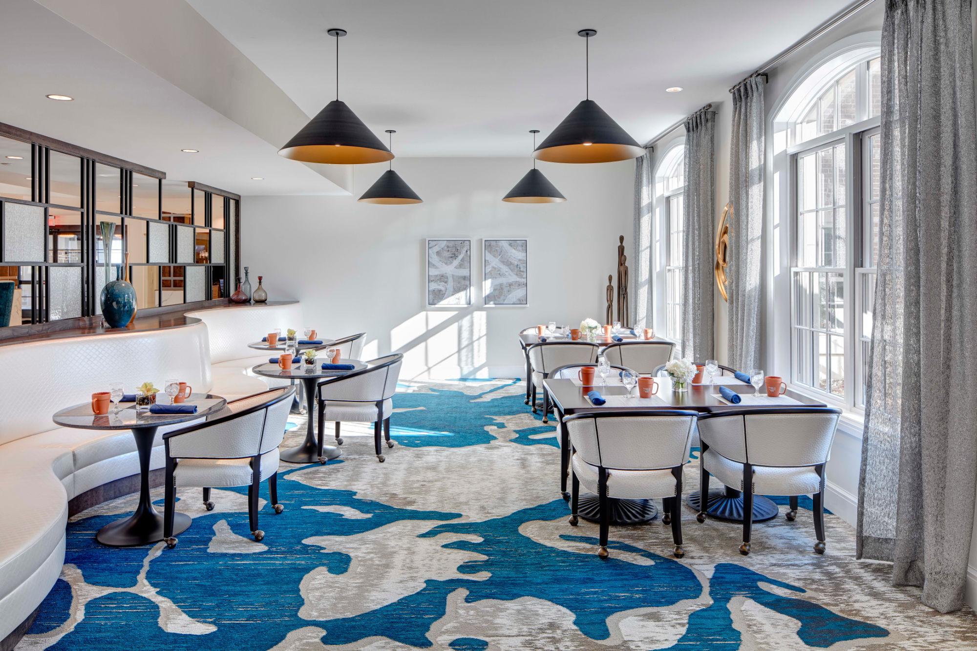 Dining lounge with large windows letting light in at Blossom Ridge in Oakland Charter Township, Michigan