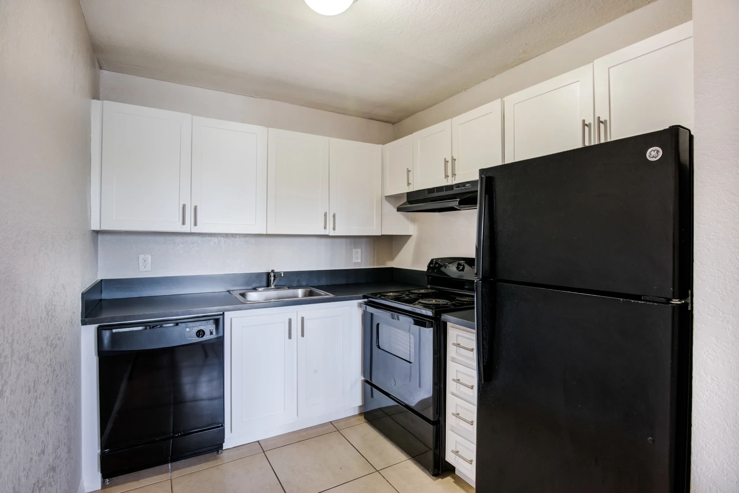 Apartment kitchen with black appliances at Coronado Springs East in Palm Springs, Florida